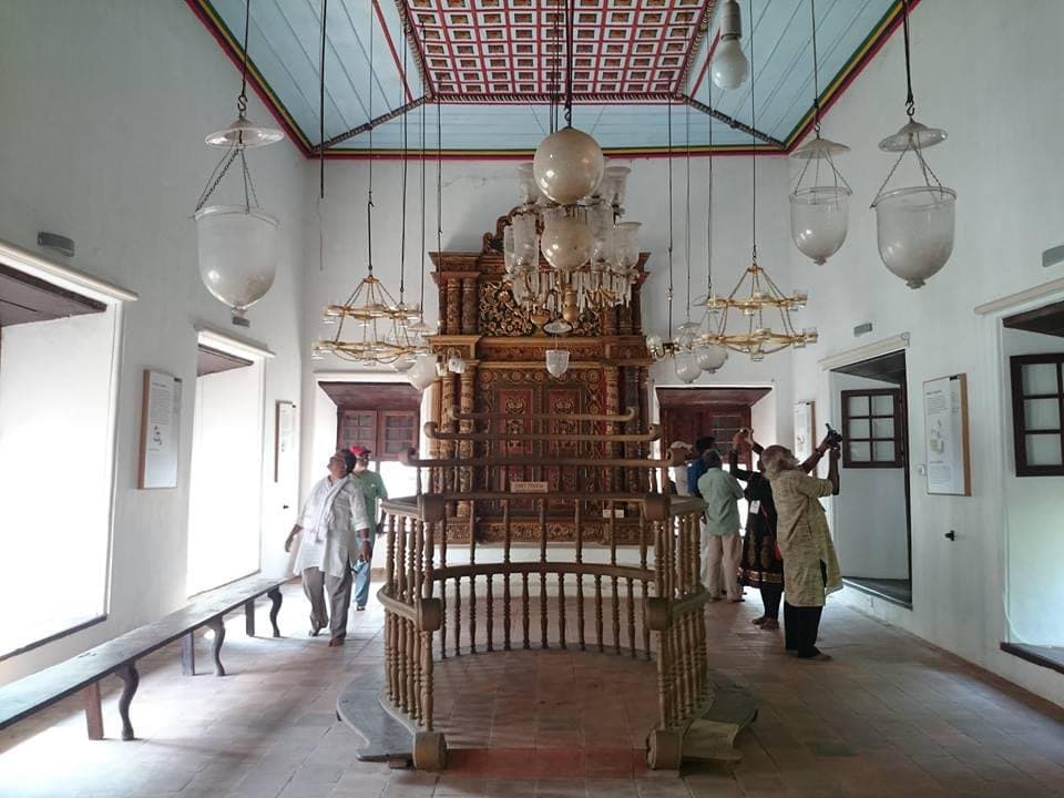 Inside the Paradesi Synagogue, Kochi — hand-painted tiles and brass chandeliers from another century.